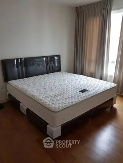 Spacious bedroom with large bed and elegant curtains, perfect for relaxation.