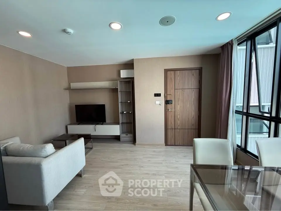 Modern living room with sleek furniture and large windows in a stylish apartment.