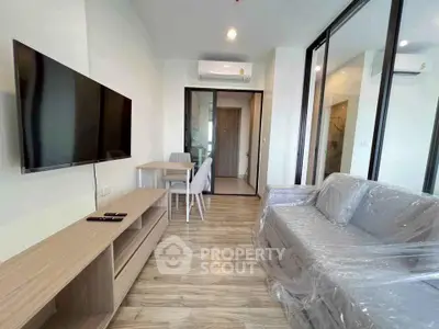 Modern living room with sleek furniture and wall-mounted TV in a stylish apartment.