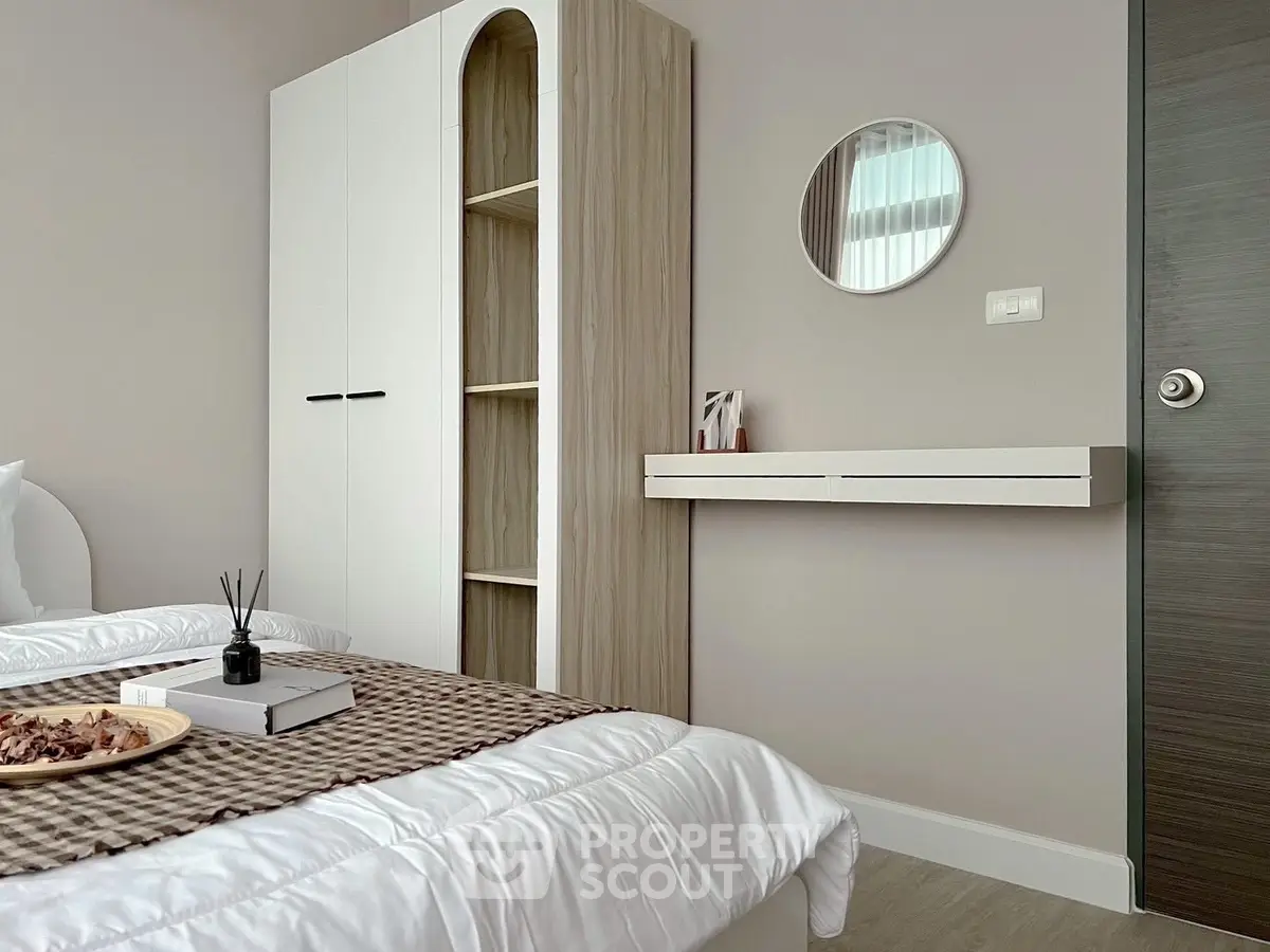 Modern bedroom with stylish decor and ample storage in a contemporary apartment.