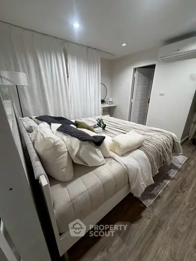 Cozy bedroom with modern decor and soft lighting, featuring a comfortable bed and stylish furnishings.