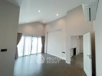 Spacious modern living room with high ceiling and large windows