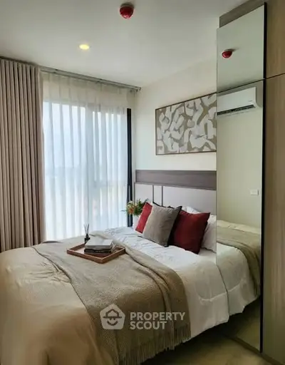 Cozy modern bedroom with stylish decor and large window for natural light.