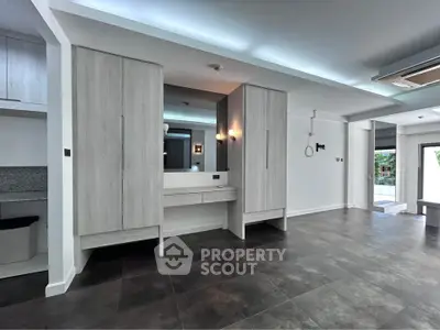 Spacious modern living room with sleek flooring and built-in storage cabinets