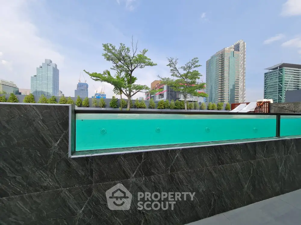 Modern rooftop pool with city skyline view and lush greenery