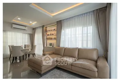 Luxurious living room with elegant leather sofa and dining area, featuring ambient lighting and stylish decor.