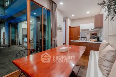 Modern dining area with wooden table and open kitchen in luxury home