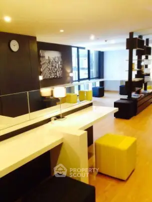 Modern living room with stylish decor and open layout, featuring sleek furniture and large windows.