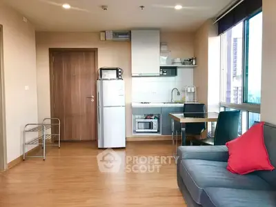Modern apartment interior with kitchen and living area, featuring sleek appliances and cozy seating.