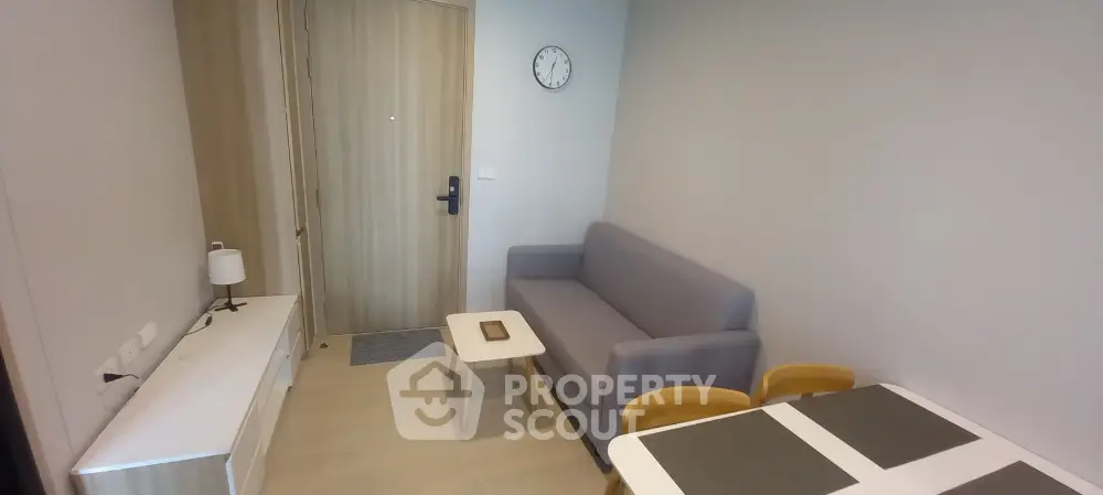 Modern living room with cozy gray sofa and dining area in stylish apartment