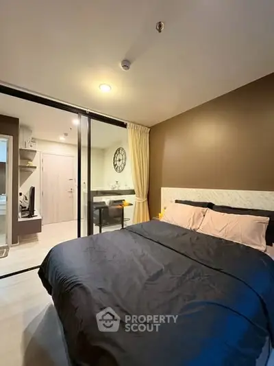 Modern bedroom with cozy decor and sliding glass doors leading to a stylish study area.