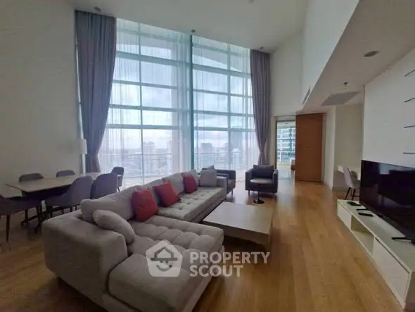 Luxurious high-rise living room with floor-to-ceiling windows and modern furnishings.