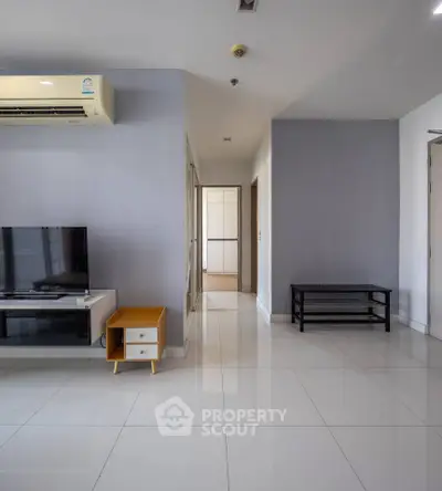 Spacious modern living room with sleek tile flooring and minimalist furniture, perfect for contemporary living.