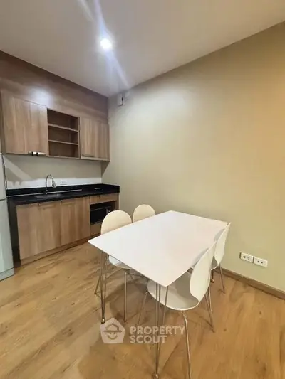 Modern kitchen with wooden cabinets and dining table in cozy apartment