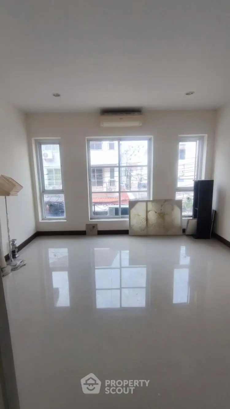 Spacious empty room with large windows and glossy floor, perfect for customization.