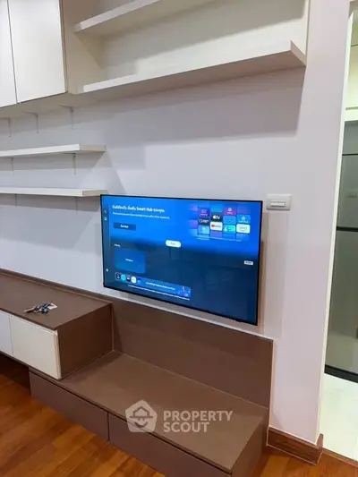 Modern living room with wall-mounted TV and sleek wooden cabinetry