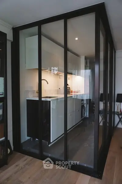 Modern enclosed kitchen with sleek glass walls and contemporary design.