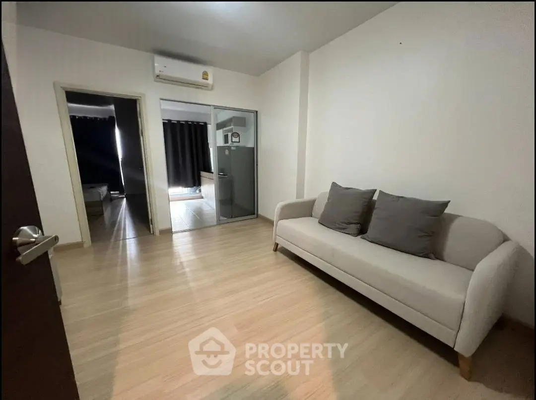 Spacious living room with modern sofa and air conditioning, ideal for comfortable living.