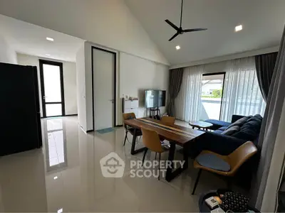 Modern living room with sleek furniture and large windows offering natural light.