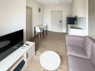 Modern living room with sleek furniture and open kitchen layout in a stylish apartment.