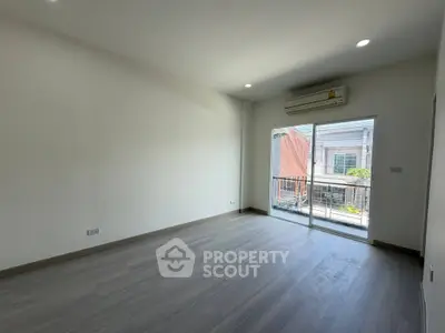 Spacious empty room with large window and balcony access, perfect for customization.