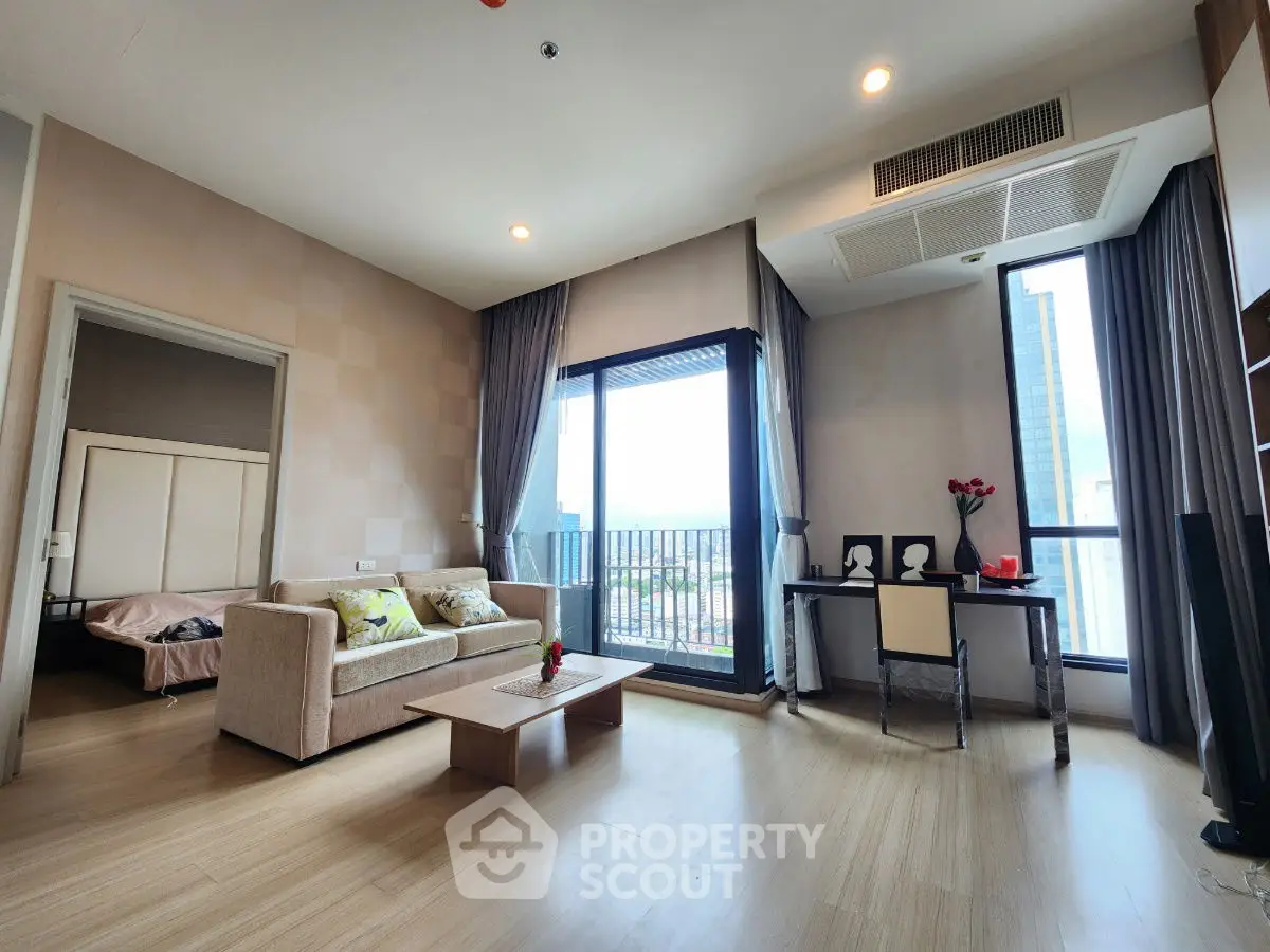 Modern living room with balcony view and stylish furniture in a high-rise apartment.