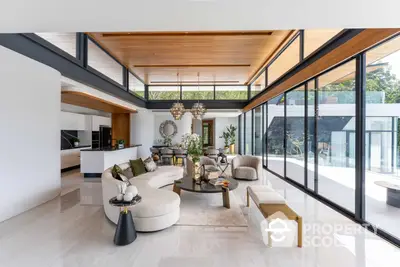 Luxurious open-plan living space with high ceilings, modern furniture, and abundant natural light from floor-to-ceiling windows, perfect for upscale living.