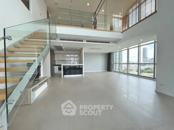 Spacious modern living room with glass staircase and city view