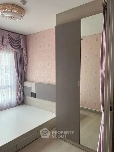 Elegant bedroom with stylish decor and large wardrobe, featuring soft pink wallpaper and luxurious curtains.