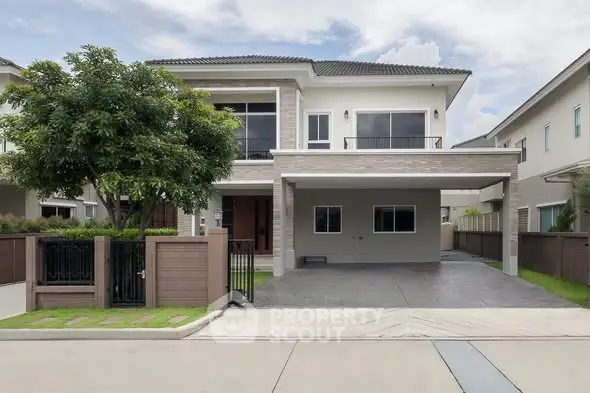 Modern two-story house with spacious driveway and lush greenery