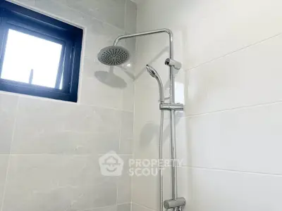 Modern bathroom shower with sleek design and tiled walls.