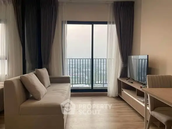 Modern living room with large window and stylish furniture, offering a serene view.