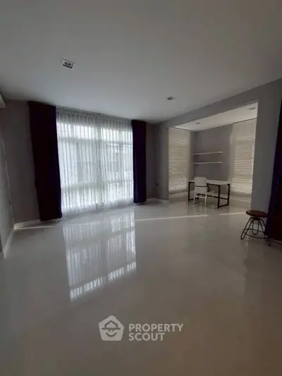 Spacious modern living room with large windows and sleek flooring