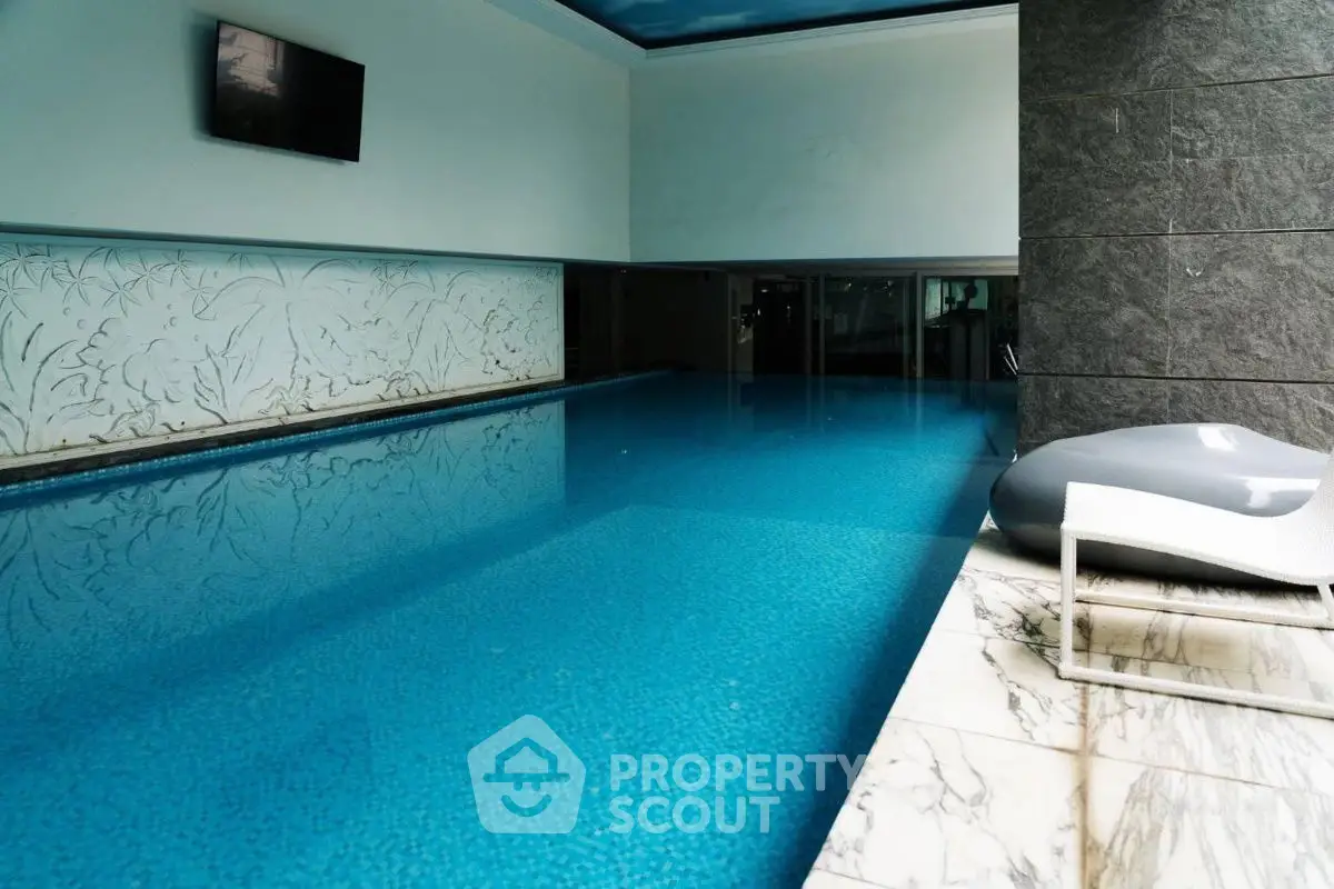 Luxurious indoor swimming pool with elegant marble accents and modern design.