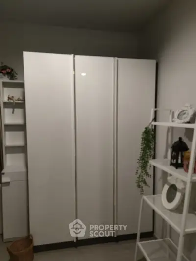 Modern storage room with sleek white cabinets and decorative shelving
