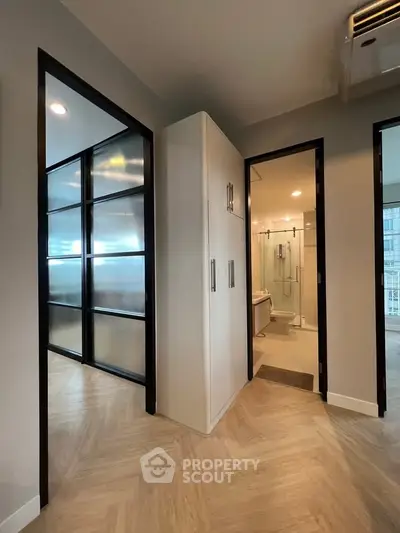 Modern apartment interior with sleek design and spacious layout, featuring a bathroom and storage area.