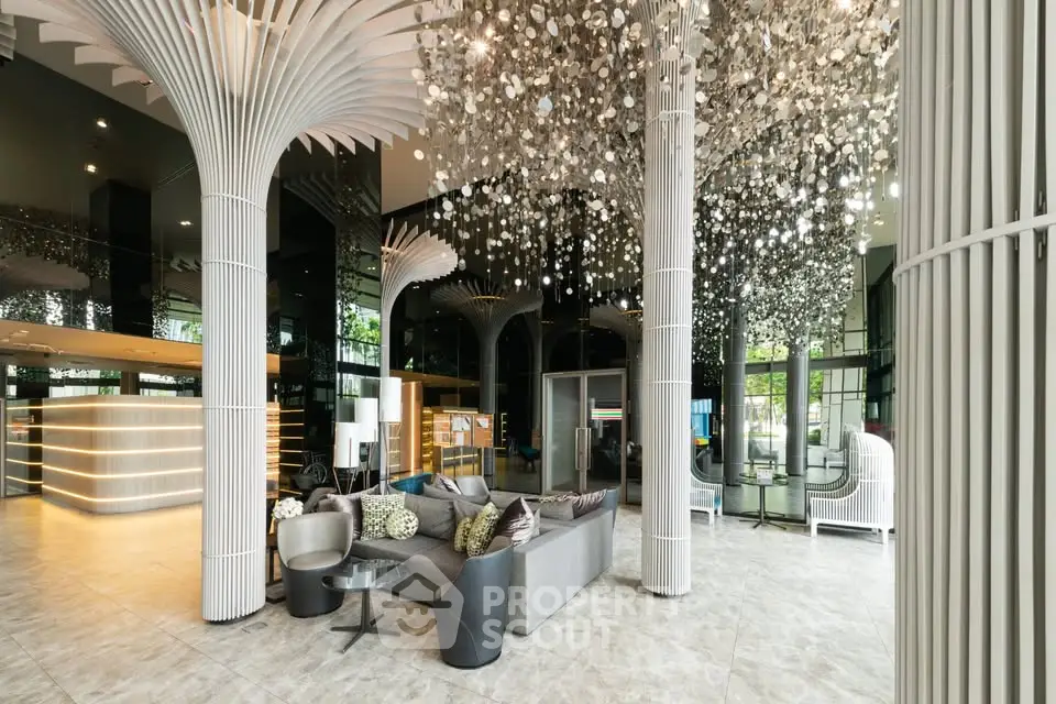Luxurious modern lobby with stunning chandeliers and elegant seating area in upscale building.