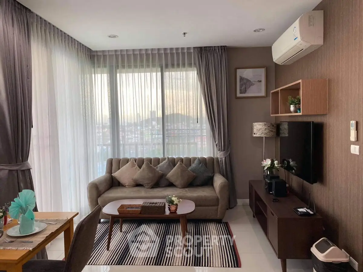 Stylish living room with modern decor and large windows offering city views.