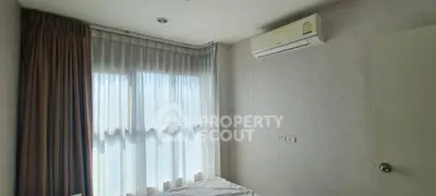 Bright bedroom with large windows and air conditioning in modern apartment.