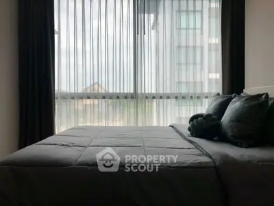 Cozy bedroom with large window and modern decor in a stylish apartment.