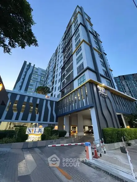 Modern high-rise building exterior with sleek design and lush greenery at Silk Place.
