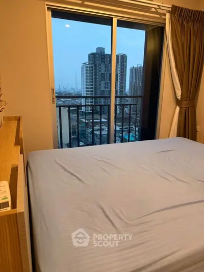 Modern bedroom with city view from balcony in high-rise apartment