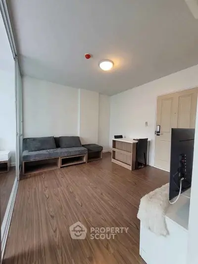 Modern living room with sleek wooden flooring and minimalist furniture design.