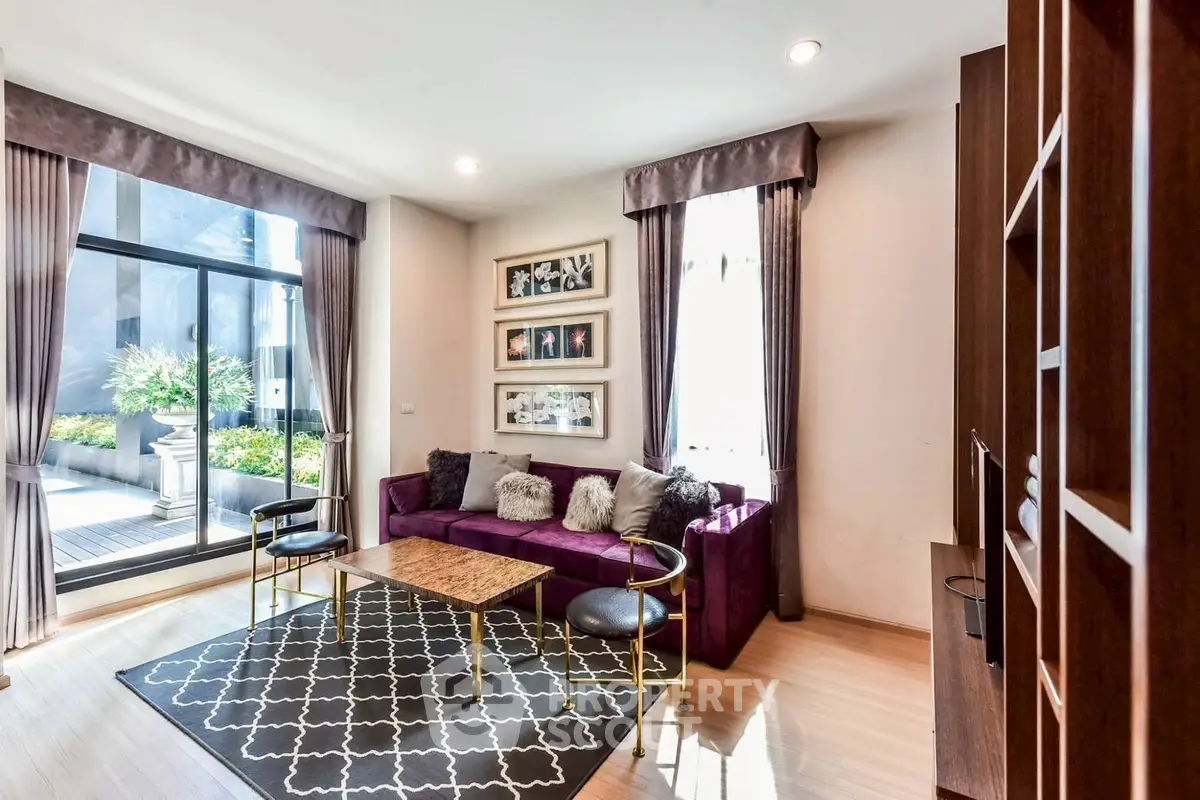 Stylish living room with purple sofa and large window overlooking garden.