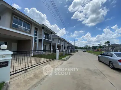 Modern suburban homes with spacious driveways under a clear blue sky.