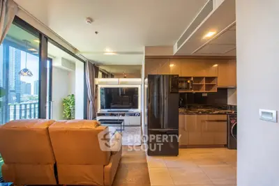 Modern open-plan living room with sleek kitchen and large windows in urban apartment