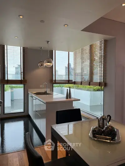 Modern kitchen with open layout and city view, featuring sleek design and natural light.