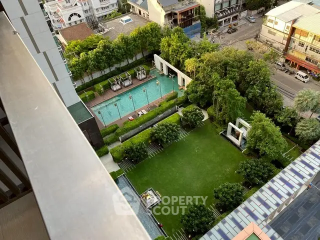 Stunning aerial view of luxury apartment complex with lush garden and inviting swimming pool.