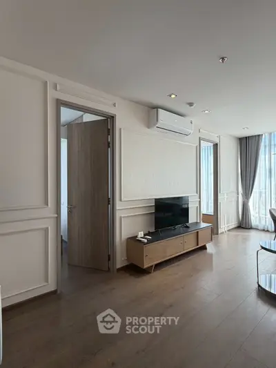 Modern living room with sleek wooden flooring and stylish TV unit