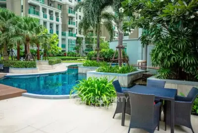 Luxurious condo pool area with lush greenery and modern outdoor seating.